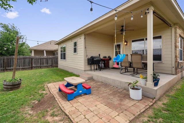 rear view of house with a yard, a patio, a ceiling fan, and a fenced backyard