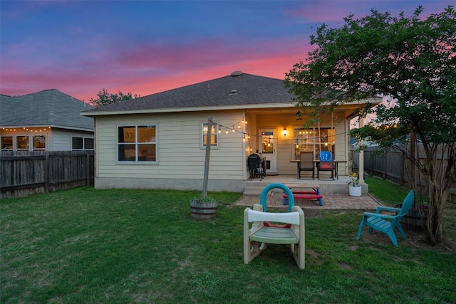 back of house featuring a yard, a fenced backyard, and a patio area