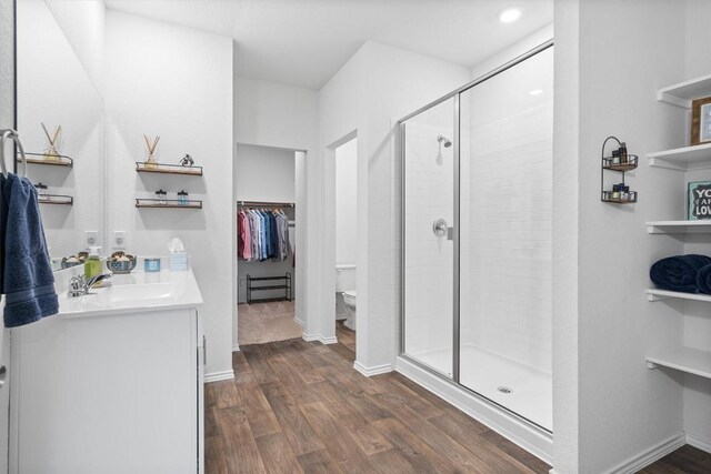 19216 Bear Grass Dr, Elgin, TX 78621 - full bath with toilet, a shower stall, a spacious closet, vanity, and wood finished floors