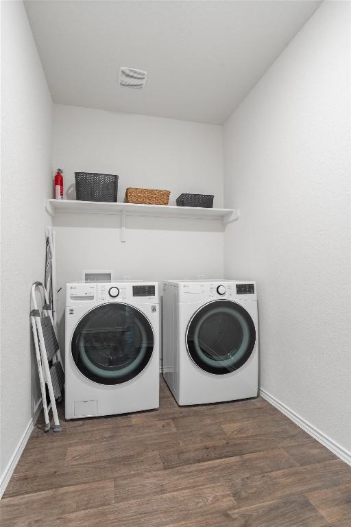 19216 Bear Grass Dr, Elgin, TX 78621 - laundry room with washer and clothes dryer, baseboards, and wood finished floors