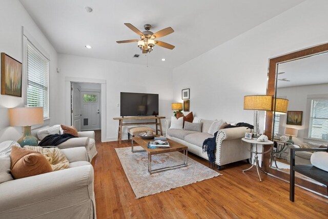 living area featuring plenty of natural light, a ceiling fan, light wood-style floors, and visible vents