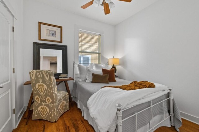 bedroom featuring baseboards, ceiling fan, and wood finished floors