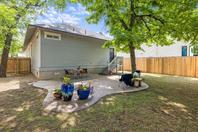rear view of property featuring a patio, a fenced backyard, and entry steps