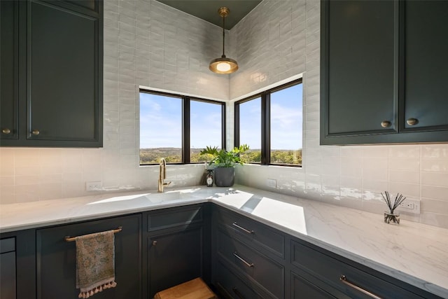 5914 Cape Coral Dr, Austin, TX 78746 - kitchen featuring backsplash, light stone counters, decorative light fixtures, and a sink