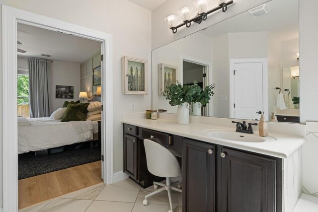 ensuite bathroom with vanity, connected bathroom, tile patterned floors, and visible vents