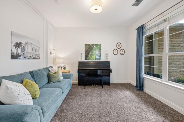 living area with a healthy amount of sunlight, baseboards, carpet flooring, and visible vents