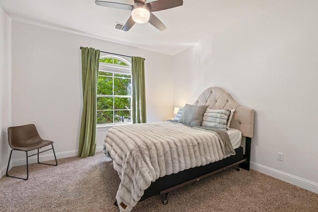 carpeted bedroom featuring visible vents, a ceiling fan, and baseboards