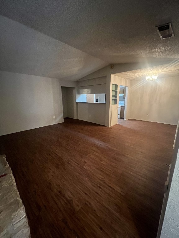 8105 Dowling Cv, Austin, TX 78745 - unfurnished living room featuring wood finished floors, vaulted ceiling, and a textured ceiling