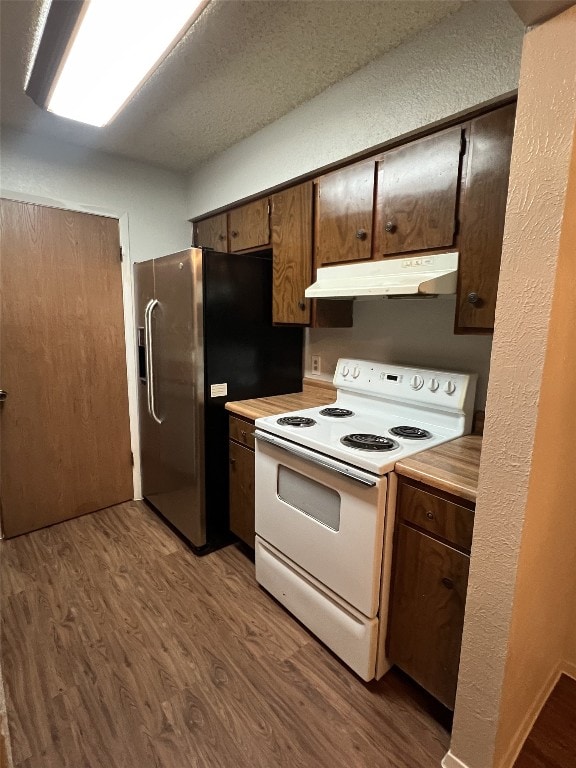 8105 Dowling Cv, Austin, TX 78745 - kitchen featuring under cabinet range hood, white electric stove, dark wood-style flooring, light countertops, and stainless steel fridge