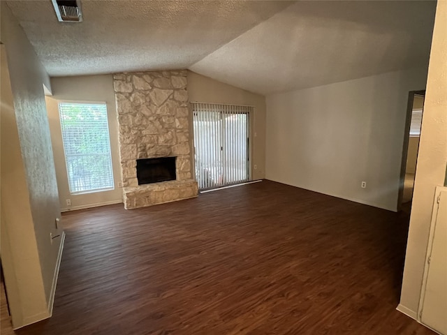8105 Dowling Cv, Austin, TX 78745 - unfurnished living room with dark wood-type flooring, lofted ceiling, a fireplace, and a textured ceiling