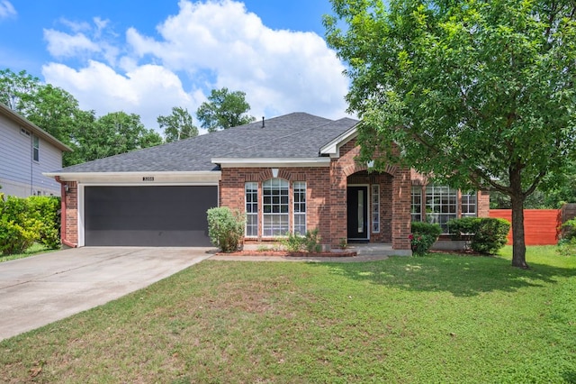 single story home with a garage, a front lawn, brick siding, a shingled roof, and driveway