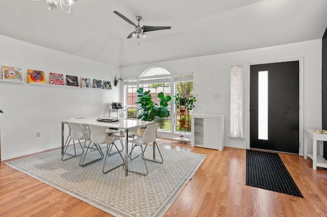 dining space featuring a ceiling fan, vaulted ceiling, and wood finished floors