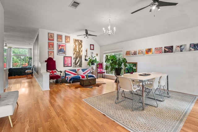 dining area with visible vents, plenty of natural light, ceiling fan with notable chandelier, and wood finished floors