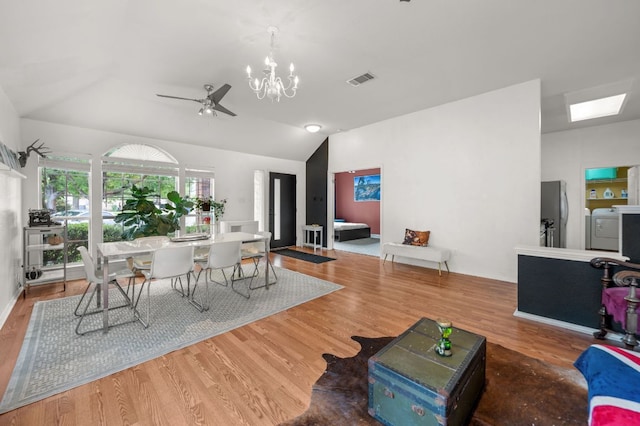 living room with visible vents, wood finished floors, vaulted ceiling, and washing machine and clothes dryer