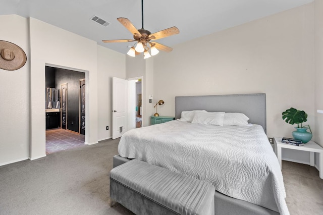 carpeted bedroom with baseboards, visible vents, ceiling fan, and ensuite bathroom
