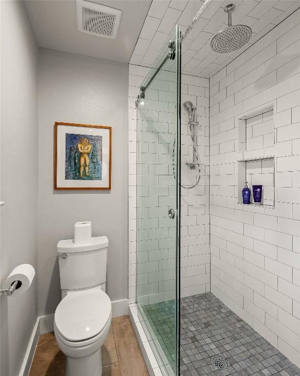 full bath featuring visible vents, baseboards, a stall shower, and toilet