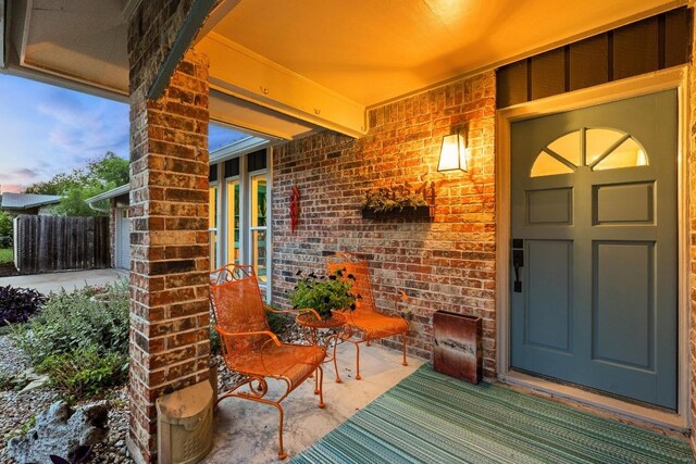 entrance to property with brick siding and fence