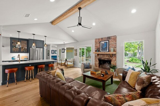 living area with visible vents, a healthy amount of sunlight, and light wood-type flooring