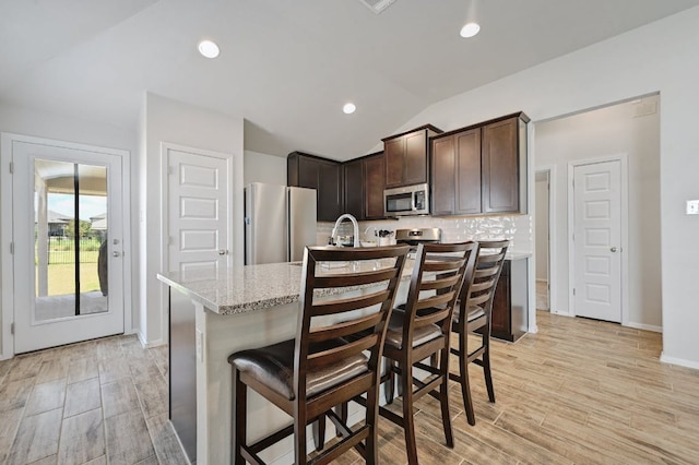 155 Lyndon Dr, San Marcos, TX 78666 - kitchen with backsplash, stainless steel appliances, light wood finished floors, and dark brown cabinets