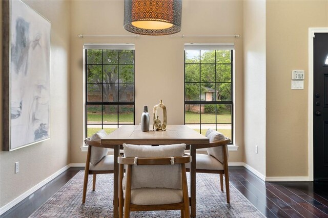 dining space featuring baseboards and dark wood-style floors