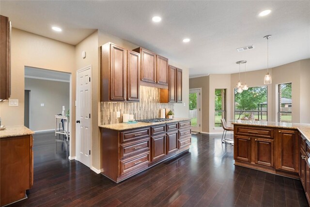 kitchen featuring visible vents, dark wood-style flooring, baseboards, backsplash, and decorative light fixtures