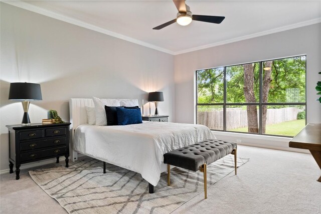 bedroom featuring carpet flooring, a ceiling fan, crown molding, and baseboards