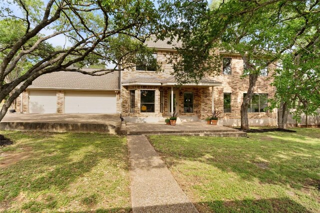 traditional-style home featuring brick siding, a front yard, and a garage