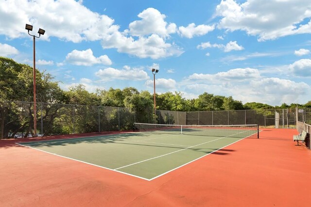 view of tennis court with fence and community basketball court