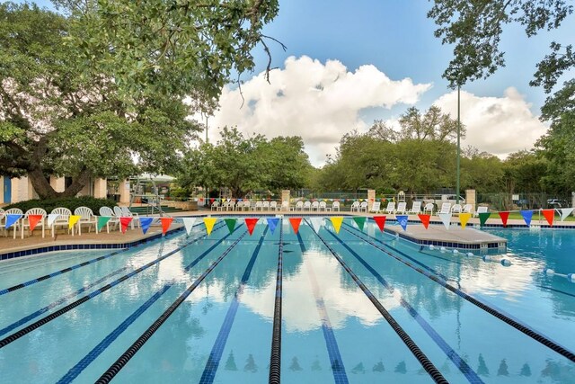 pool with a patio and fence