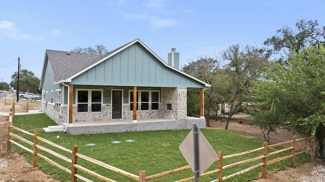 602 Shorewood Dr, Granite Shoals, TX 78654 - bungalow-style home with a shingled roof, a front lawn, board and batten siding, and stone siding