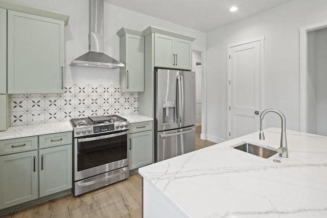 602 Shorewood Dr, Granite Shoals, TX 78654 - kitchen featuring appliances with stainless steel finishes, a sink, light wood-style flooring, wall chimney exhaust hood, and tasteful backsplash
