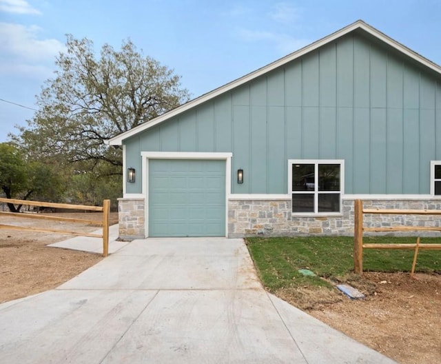 602 Shorewood Dr, Granite Shoals, TX 78654 - view of property exterior with fence, stone siding, a garage, board and batten siding, and driveway