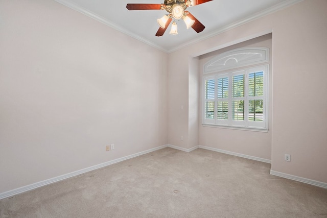 empty room featuring crown molding, baseboards, a ceiling fan, and light colored carpet