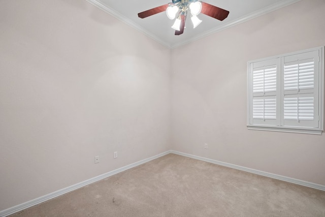 carpeted spare room featuring baseboards, ornamental molding, and a ceiling fan