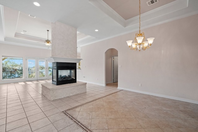 unfurnished living room featuring crown molding, a tray ceiling, ceiling fan with notable chandelier, and visible vents