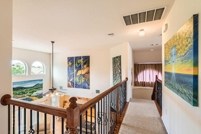 corridor featuring a wealth of natural light, an upstairs landing, and visible vents