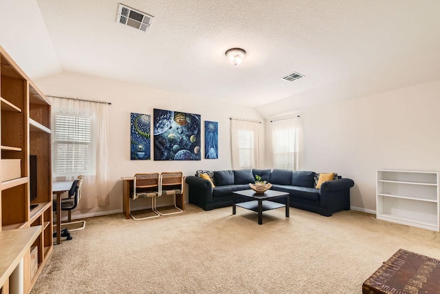 carpeted living area with vaulted ceiling, a healthy amount of sunlight, and visible vents