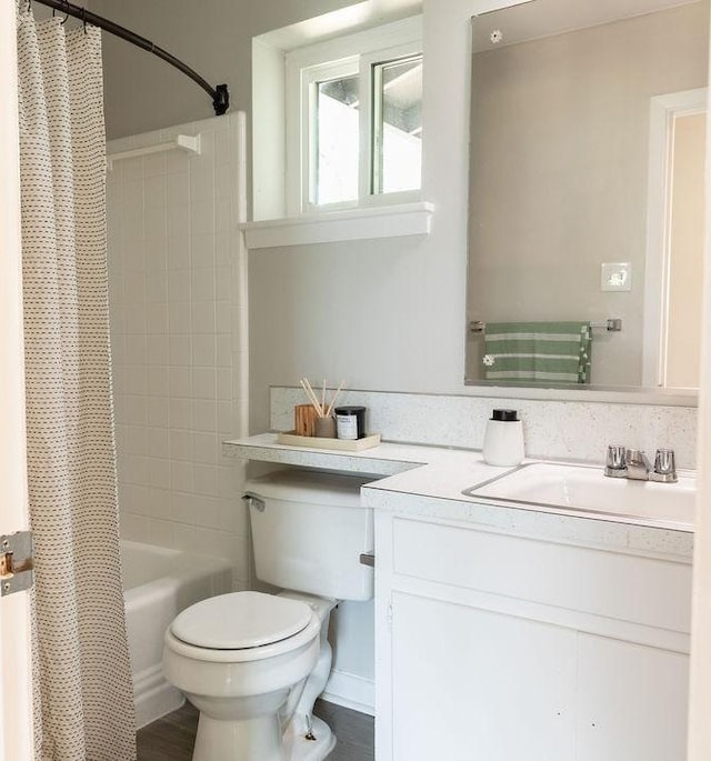 bathroom with toilet, shower / bath combo with shower curtain, and vanity