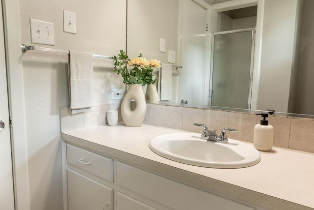 bathroom featuring vanity, tasteful backsplash, and a stall shower