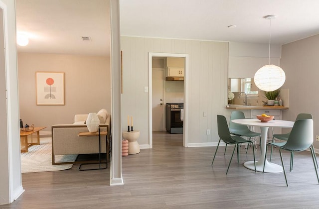 dining area with baseboards, wood finished floors, and visible vents