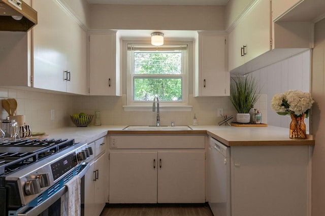 kitchen featuring white dishwasher, stainless steel gas range oven, light countertops, under cabinet range hood, and a sink