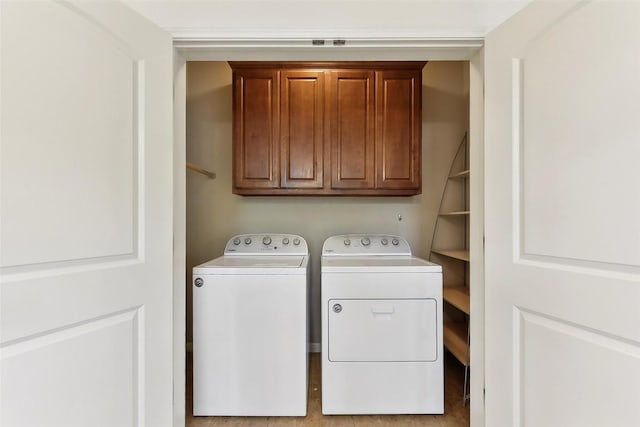 clothes washing area featuring cabinet space and washing machine and clothes dryer