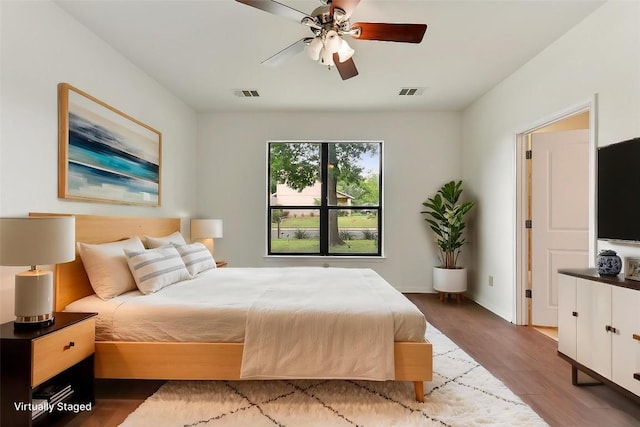 bedroom featuring a ceiling fan, wood finished floors, and visible vents