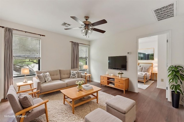 living room with a ceiling fan, baseboards, visible vents, and wood finished floors