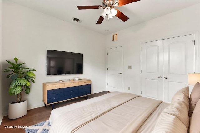 bedroom featuring baseboards, visible vents, wood finished floors, and a closet
