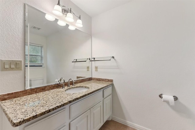 half bath featuring visible vents, vanity, toilet, baseboards, and tile patterned floors