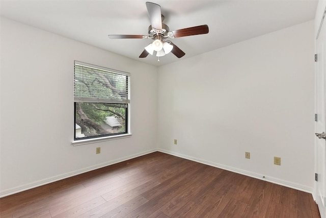 empty room with dark wood-type flooring, baseboards, and ceiling fan