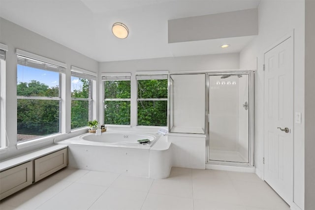 bathroom with tile patterned flooring, a garden tub, and a stall shower