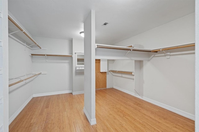 spacious closet featuring visible vents and wood finished floors