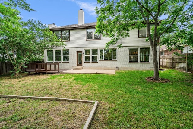 rear view of house with brick siding, a patio, a chimney, and a fenced backyard